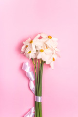 Seasonal flowers in a minimalistic bouquet on a bright background.