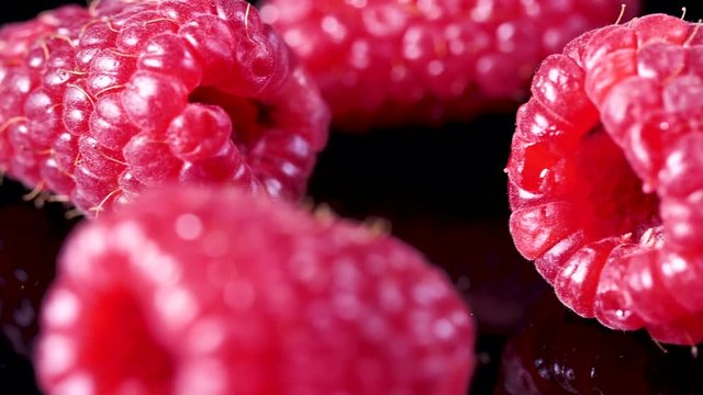 Nahaufnahmeansicht der frischen saftigen Himbeere auf schwarzem Hintergrund Video