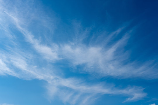 Bright blue sky with misty clouds
