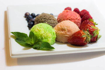 Set of ice cream scoops of different colors and flavours with fruits decoration isolated on white background 