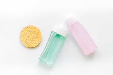 facial tonic, lotion and sponge for face care on white background top view mock up