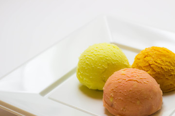 Set of ice cream scoops of different colors and flavours with fruits decoration isolated on white background 