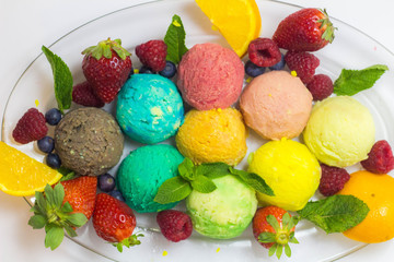Set of ice cream scoops of different colors and flavours with fruits decoration isolated on white background 