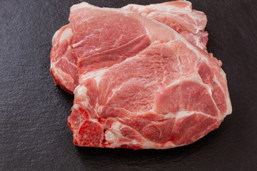 a piece of pork meat on the black plate