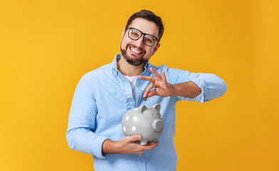 concept of Finance and business.  man with  piggy Bank on  yellow background color