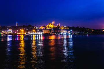 Fototapeta premium Night view of Istanbul. Panorama cityscape of famous tourist destination Golden Horn bay part of Bosphorus strait. Travel illuminated landscape Bosporus, Turkey, Europe and Asia.