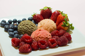 Set of ice cream scoops of different colors and flavours with fruits decoration isolated on white background 