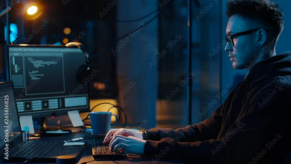 Poster cybercrime, hacking and technology concept - asian male hacker in glasses writing code or using comp