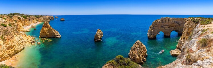 Natural caves at Marinha beach, Algarve Portugal. Rock cliff arches on Marinha beach and turquoise...