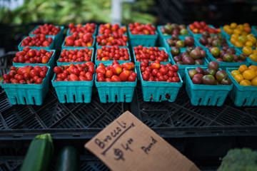 In paper containers packed tomatoes cherry ready for sale in a vegetable farmer's market. Tomatoe grapes on display at the market. Eco product. Ecology and preservation of the environment concept.