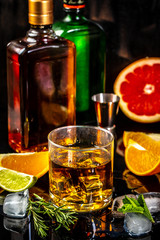 glass of whiskey with ice cubes on wood table, warm atmosphere, time of relax with whisky. concept luxury drink