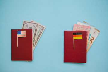 Foreign passports with the flag of the USA and Germany and US dollars and Euros on a blue background. The concept of migration, work and travel.