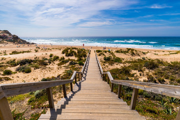 Fototapeta na wymiar View of the Monte Clerigo beach on the western coastline of Portugal, Algarve. Stairs to beach Praia Monte Clerigo near Aljezur, Costa Vicentina, Portugal, Europe.
