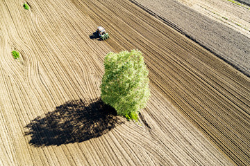 Trattore al lavoro in campo arato - vista aerea