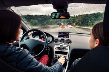 Mother driving daughter in the car on the highway