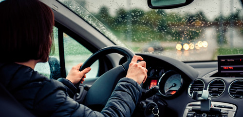 Woman driving car on the motorway in the rain