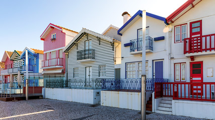 Fototapeta na wymiar Street with colorful houses in Costa Nova, Aveiro, Portugal. Street with striped houses, Costa Nova, Aveiro, Portugal. Facades of colorful houses in Costa Nova, Aveiro, Portugal.