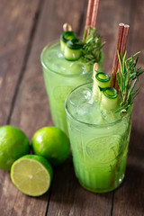 Green ice cold tropical lime smoothie served with ice in two glasses