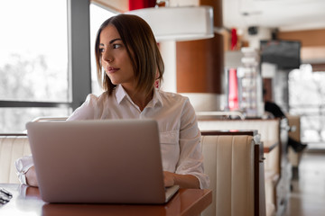 Beautiful  young woman is working on her lap top in the coffee shop