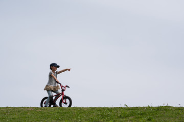 草原で自転車に乗る女の子
