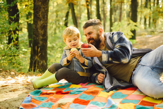 Forest Picnic Hiking. Healthy Lifestyle. Nature Picnic. Healthy Snack. Vitamin Charge. Family Picnic. Hipster Bearded Dad With Son Spend Time In Forest. Brutal Bearded Man And Little Boy Eat Apples