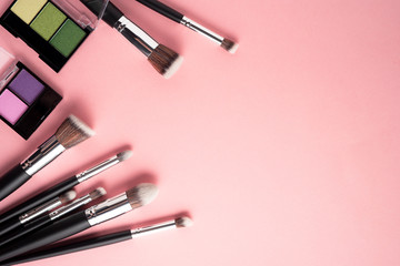 Creative concept beauty fashion photo of cosmetic product make up brushes kit on pink background.