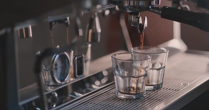 Coffee flows from cofee machine in slow motion