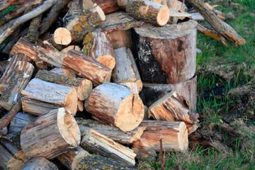 Natural wood background - closeup of chopped firewood. Firewood stacked and prepared for winter. A pile of firewood by the road.