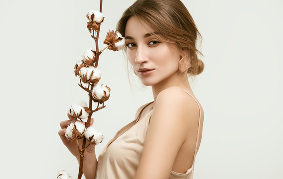 Sensual portrait of glamor woman model among cotton twigs