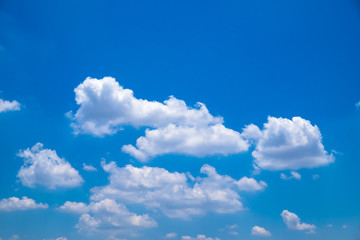 Naklejka na ściany i meble Fuffy clouds on bright blue sky background.