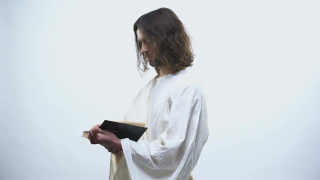Saint prophet reading Bible illuminated with light, prayer and faith in God