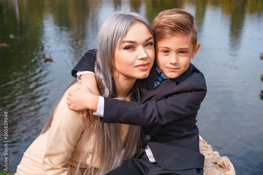 Wall mural happy mom and son hugging outdoors by the lake