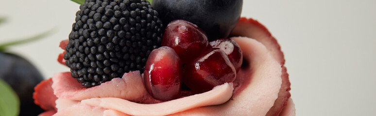 panoramic shot of cream with garnet, blackberry and grape isolated on grey