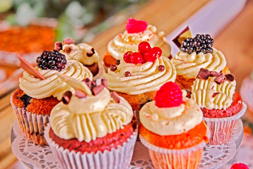 deliciously arranged muffins with cream filling and garnished with fruits on a wedding buffet