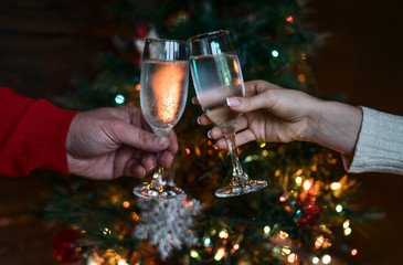 Holiday and togetherness near Christmas tree. Merry Christmas and Happy New Year 2018! Christmas party time. Couple toasting with champagne. Celebration concept, holiday background, selective focus.