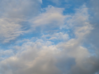 Fototapeta premium Moon in blue sky seen through cloudscape
