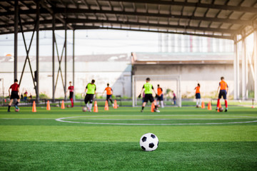 football on green artificial turf with blurry soccer team training
