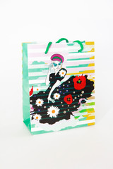a multi-colored gift bag with a pattern in the form of a girl in a dress on a white background