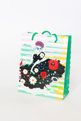 a multi-colored gift bag with a pattern in the form of a girl in a dress on a white background