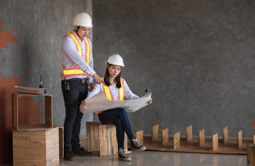 Male engineer and female engineer Viewing Blueprints