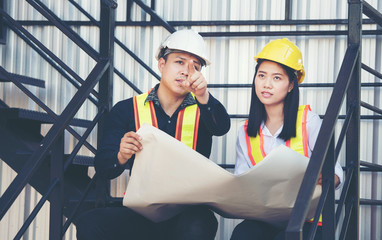 Male engineer and female engineer Viewing Blueprints 