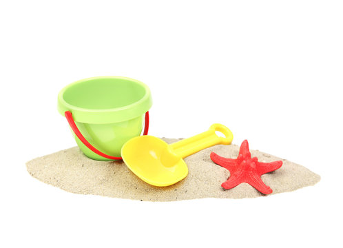 Plastic bucket and showel on sand isolated.