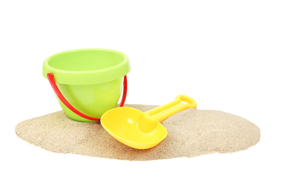 Plastic bucket and showel on sand isolated.