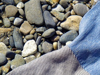 Summer vacation impressions - handmade blanket from old jeans lying on the sand