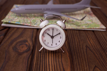 Alarm, the aircraft, a geographical map on the background of wooden table. travel, air travel.