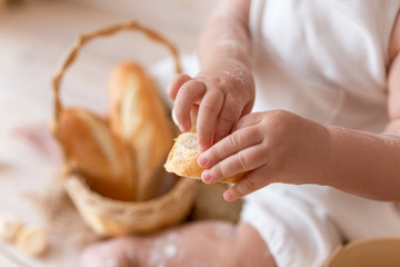 hands of little baker in the kitchen in flour