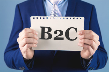 businessman holding a paper with the inscription B2C