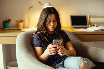 Teenage girl looking at her mobile phone