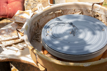 Outdoor pottery workspace with closeup potter's wheel. Nobody background concept