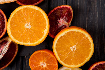 Top view. Sliced in half juicy oranges on a dark wooden background.